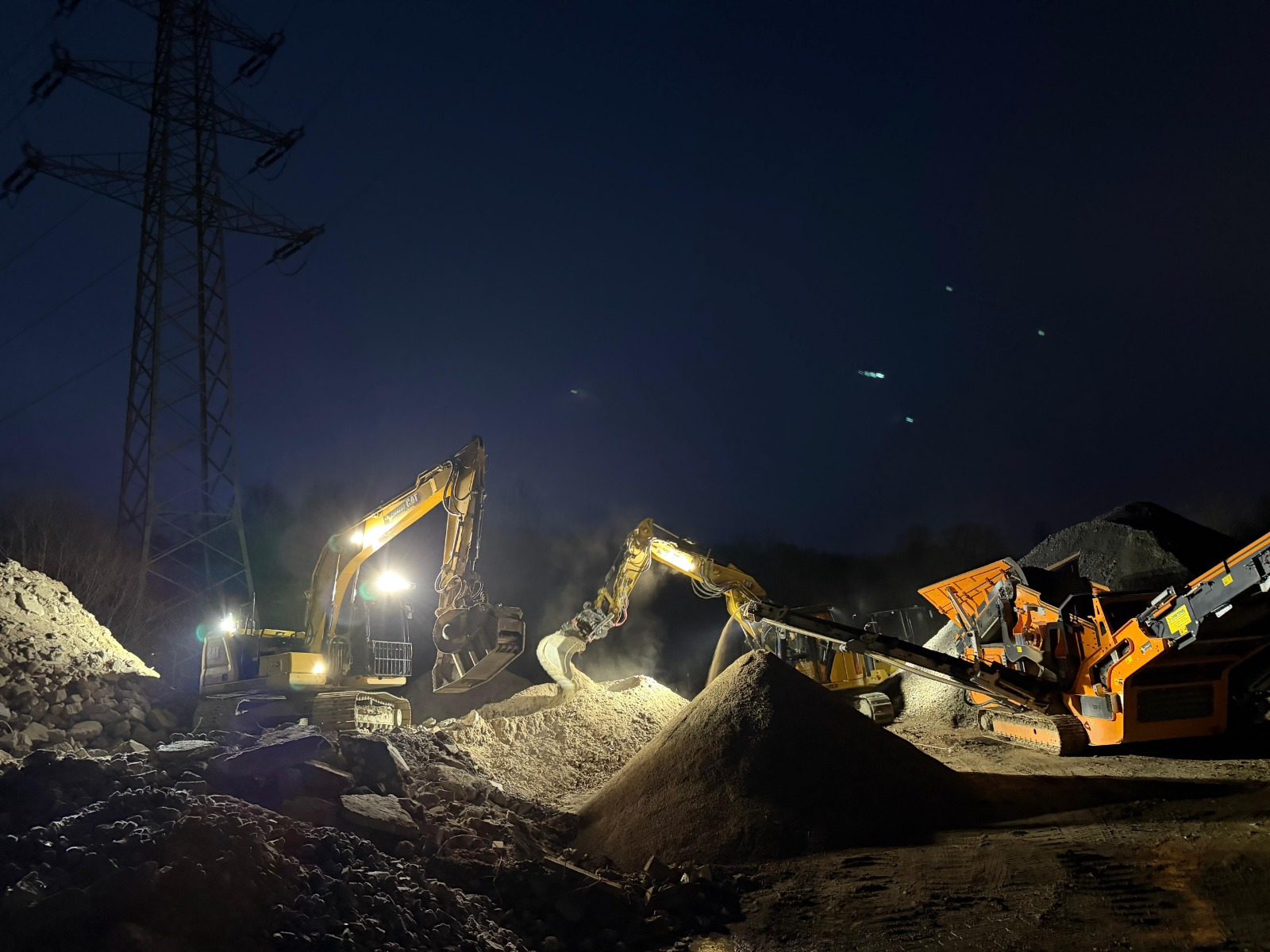 Bagger und Brechanlage von Christ Meisterbetrieb bei Nacht auf der Baustelle